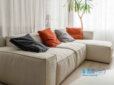 Un divano bianco con cuscini arancioni in un soggiorno.
