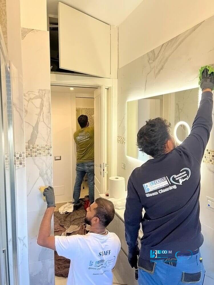 Un tecnico esperto al lavoro per la pulizia di un bagno, con eleganti pareti in marmo a Settimo Milanese.