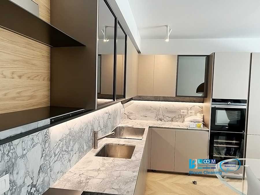 Interni di una cucina moderna con accenti di legno, ripiani in marmo e un focus su "pulizia appartamenti Milano.