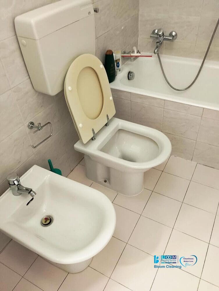 Un bagno a San Donato Milanese è dotato di un water, un bidet a sinistra del water e una vasca da bagno con soffione. Il pavimento e le pareti sono piastrellati in un colore chiaro, garantendo pulizia bagno per un risultato sorprendente.