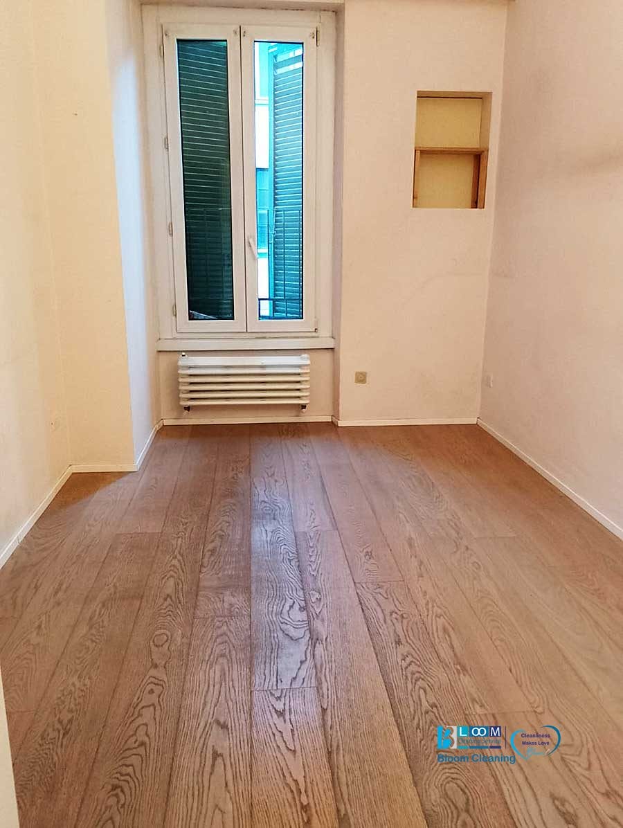 La stanza è caratterizzata da un pavimento in legno, pareti bianche e una finestra con persiane chiuse sopra il radiatore. Una piccola mensola incassata impreziosisce una parete, creando uno spazio invitante che sembra pronto per il tuo tocco personale, una vera bozza automatica in attesa del suo capolavoro finito.