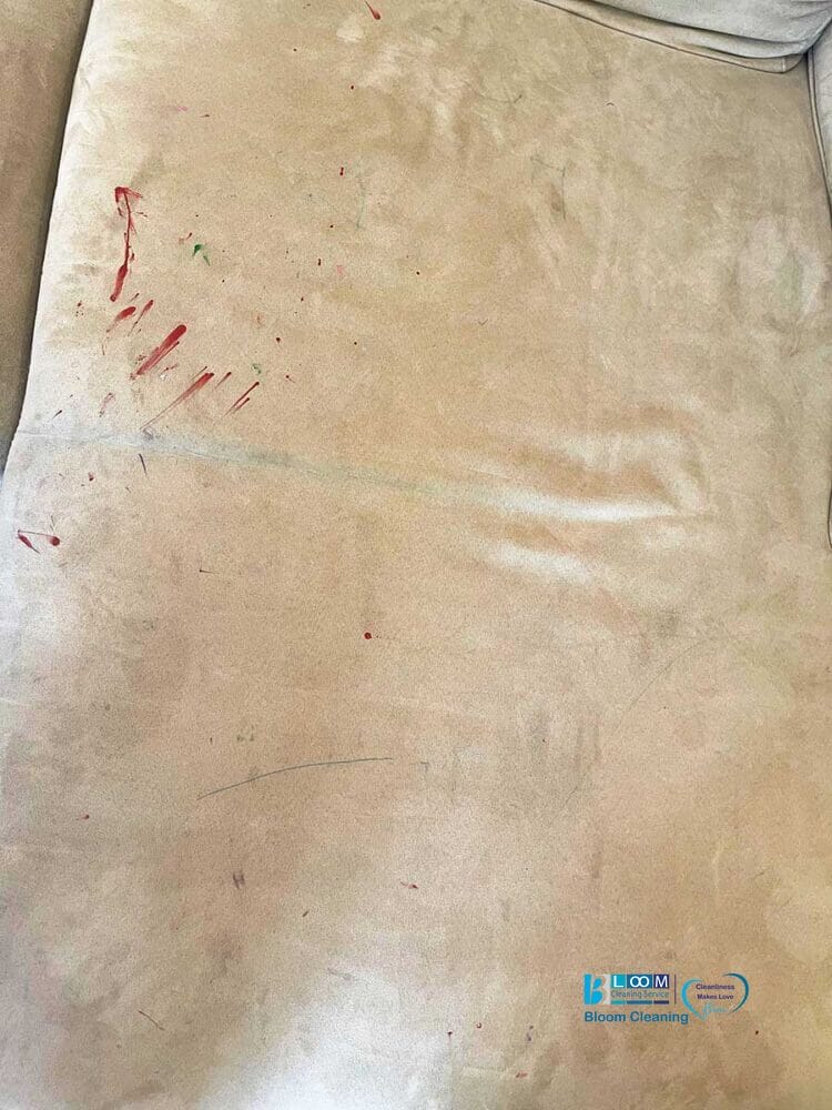 Un divano beige con varie macchie rosse e blu, quasi una bozza automatica di arte spontanea.