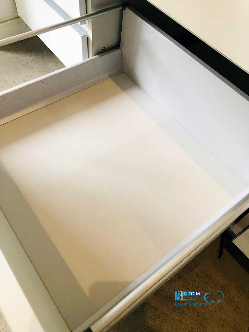 Un cassetto bianco aperto e vuoto, con le ringhiere metalliche in un mobile, ricorda una bozza automatica, in attesa del suo contenuto, guidato con precisione.