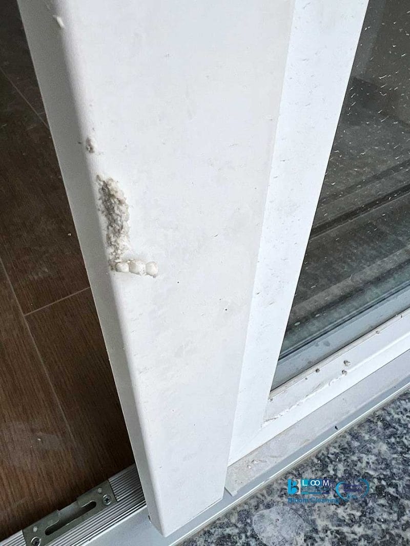 Primo piano di uno stipite di una porta bianca con una piccola area di danno visibile e una consistenza ruvida e irregolare: potrebbe necessitare di pulizia post cantiere Nerviano per ripristinarne l'aspetto.