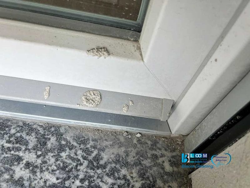 Macchie bianche e residui polverosi sul davanzale e sulla cornice di una finestra accanto a una superficie in granito, spesso visibili dopo la pulizia post cantiere Nerviano.