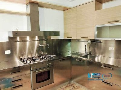 Cucina moderna con elettrodomestici in acciaio inox, forno, fornelli a gas, lavello e armadietti in legno chiaro: l'ideale per pulizie appartamenti arredati Melzo per mantenere lo spazio pulito e accogliente.