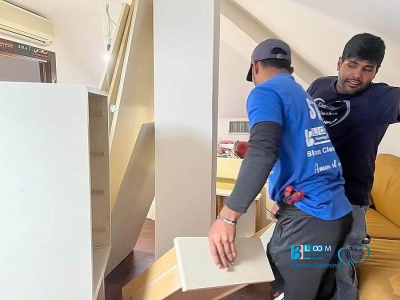 Due uomini spostano una scaffalatura bianca su per le scale di un'abitazione. Questo attento lavoro di squadra fa parte di un servizio sgombero e pulizia casa Milano, che garantisce un'efficiente rimozione dei mobili e risultati impeccabili.