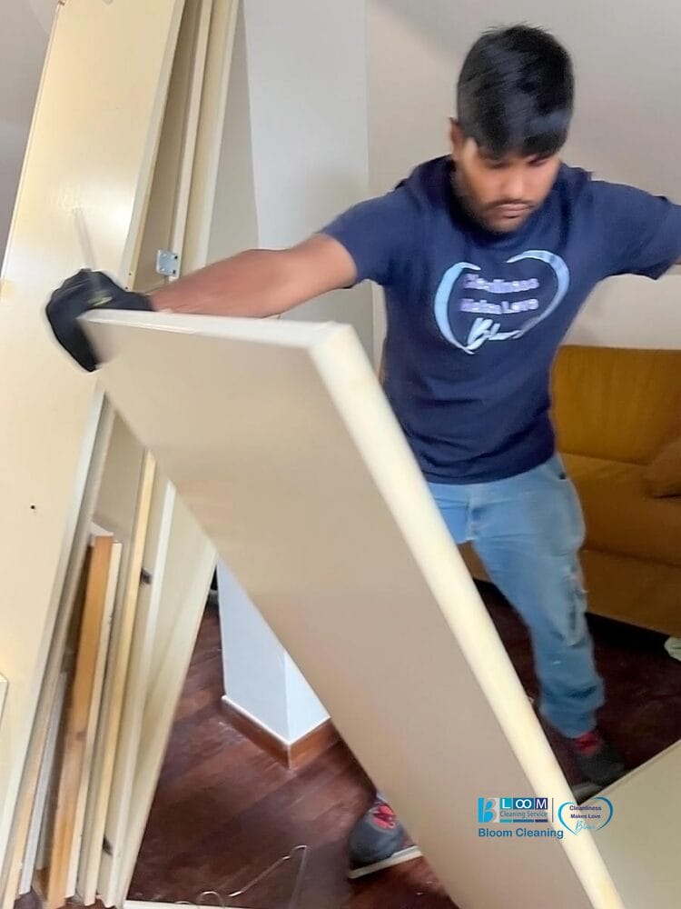 Un uomo che regge una porta bianca durante un servizio sgombero e pulizia casa Milano, pronto per lo smaltimento mobili ingombranti.